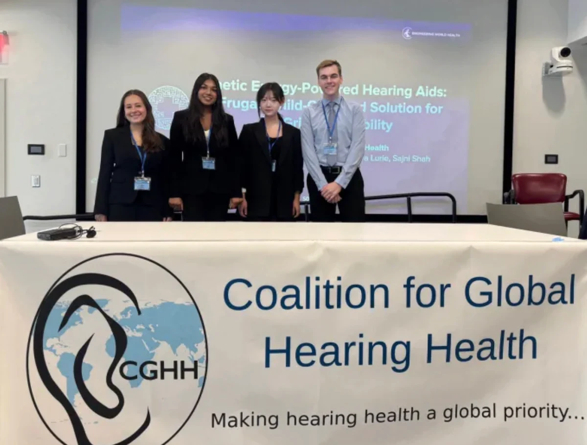 Engineering World Health team presenting the Solar Ear kinetic-energy hearing aid project at a Boston conference
