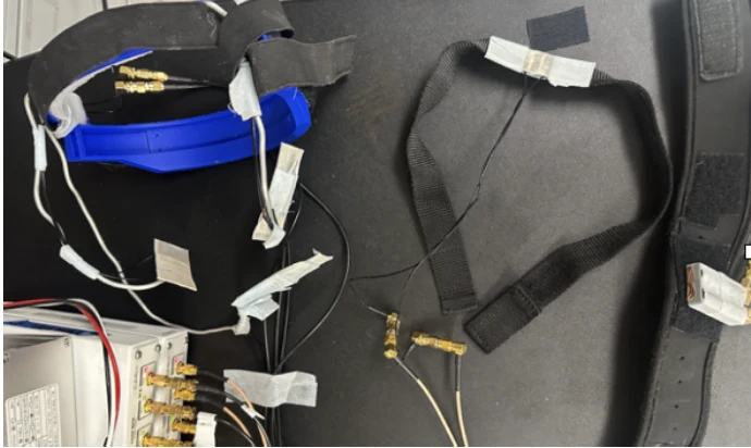 Complete RMG hardware configuration with head-mounted and throat sensors connected to a USRP radio.
